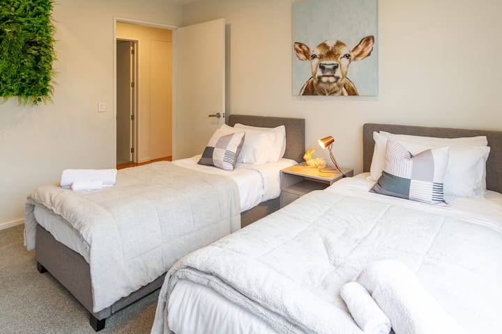 בחדר השינה הנוח הזה יש שתי מיטות יחיד, ארון בגדים מובנה מרווח ומדף ספרים שופע ספרים. קופסת צעצועים מוסיפה מגע שובב, מה שהופך אותה למקום מזמין גם למנוחה וגם למשחק.