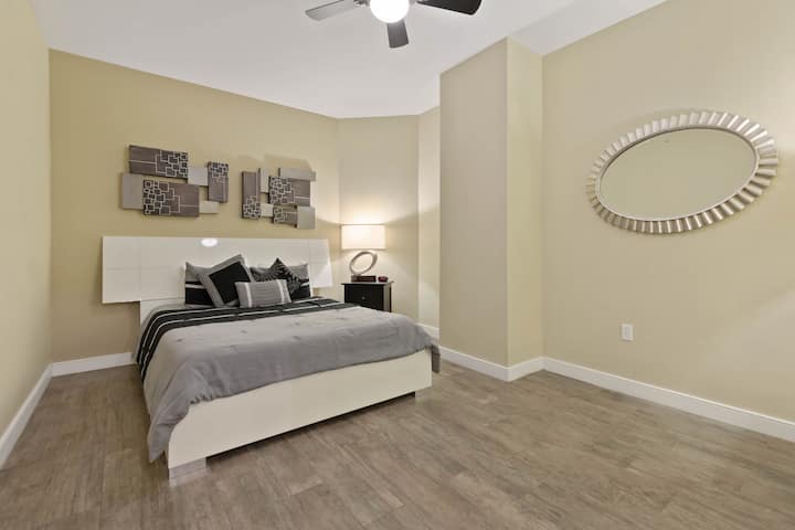 חדר שינה פנימי 3 עם מיטת קווין סייז, מאוורר תקרה, שידה וטלוויזיה עם כבלים בסיסיים.