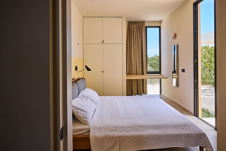 King bed and ensuite bathroom. Blackout curtains. Desk. Sliding door to patio. 