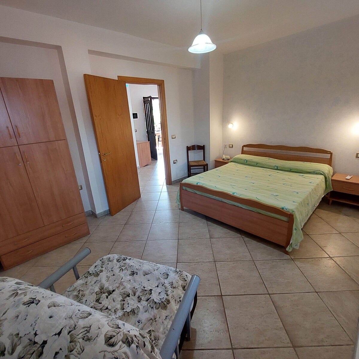 غرفة نوم مكيفة الهواء مع خزنة وسرير أريكة.