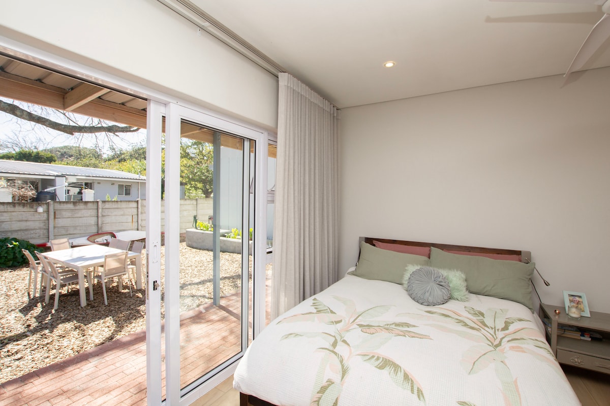 تتميز هذه الغرفة الكبيرة الهادئة بسرير بحجم كوين، وحمام دش خاص، وأبواب منزلقة تفتح مباشرة على فناء حديقة هادئ — مثالي لأشعة الشمس الصباحية أو الهواء المسائي.

