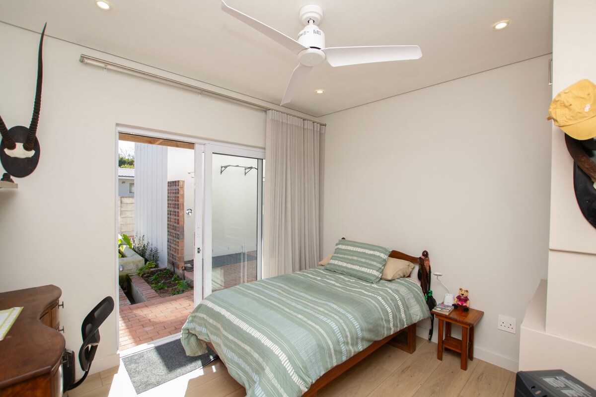 مساحة مشرقة وخاصة مع سرير مريح مقاس ¾، وأبواب منزلقة تفتح على الحديقة، وحمام كامل مخصص على بعد خطوات فقط — مثالي للأطفال الأكبر سنًا أو الضيوف المنفردين.