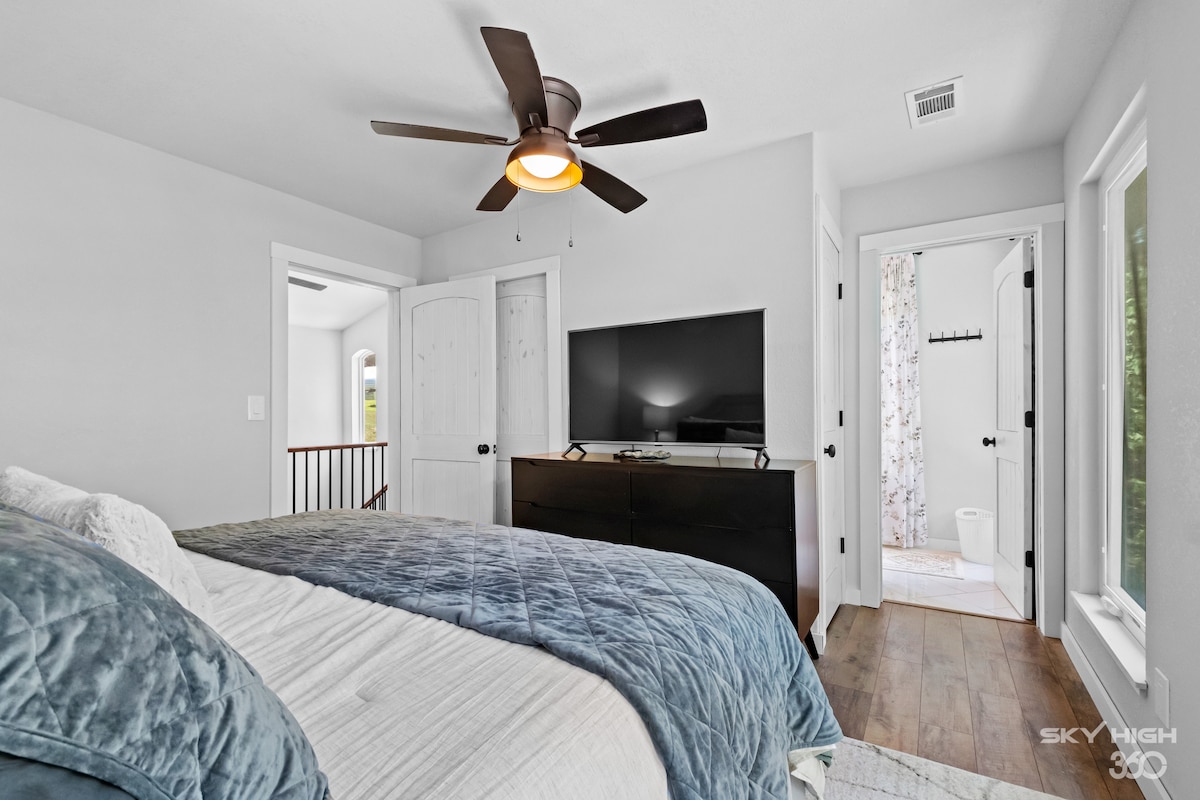 Dormitorio principal con baño privado y TV grande. 