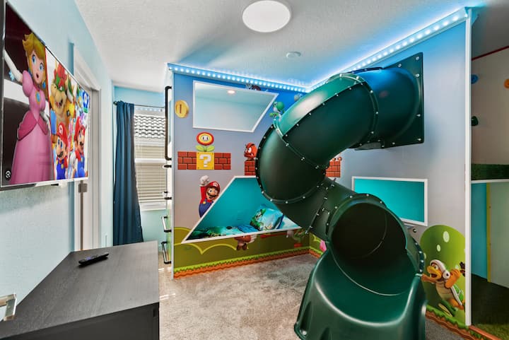 – spavaća soba s temom Super Maria i ugrađenim toboganom za dodatnu zabavu – šarene zidne slike i razigrani dizajn oživljavaju prostoriju – zabavan prostor s TV zabavnim sadržajem za djecu  