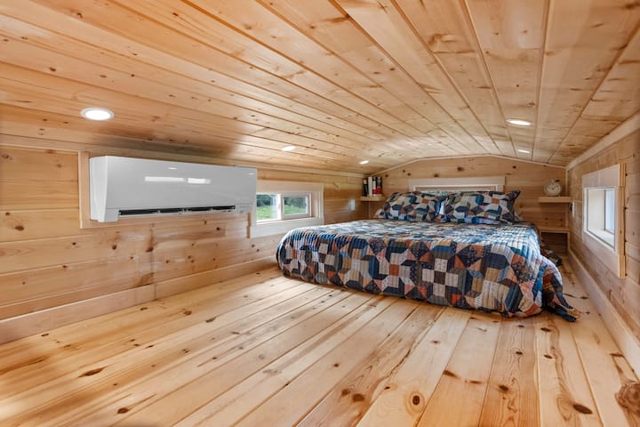 The oversized loft of the Slate Cottage has a queen sized bed and an amazing tree house-like view of the farm.