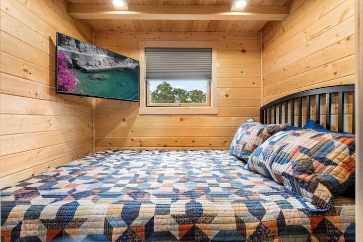 The bedroom area of the Slate has a queen sized bed and a smart television.