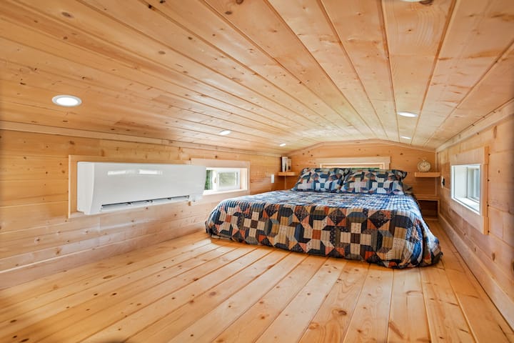 The oversized loft of the Forest Cottage has a queen sized bed and an amazing tree house-like view of the farm.