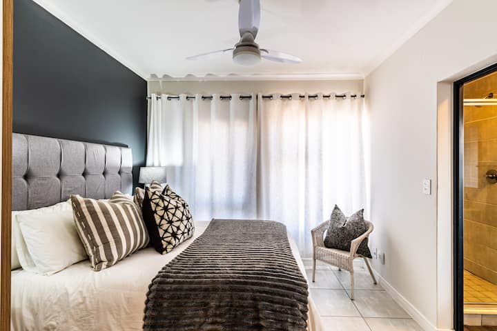 غرفة نوم مشرقة وجيدة التهوية مع سرير فخم وبياضات ناعلى طبقات لإقامة مريحة.