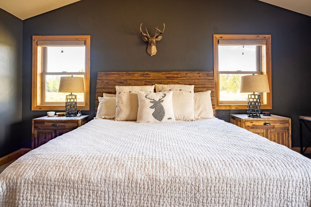 سرير كينج مع حمام داخلي كبير خاص مع حوض استحمام عميق ودش منفصل ومنضدة تزيين مزدوجة.