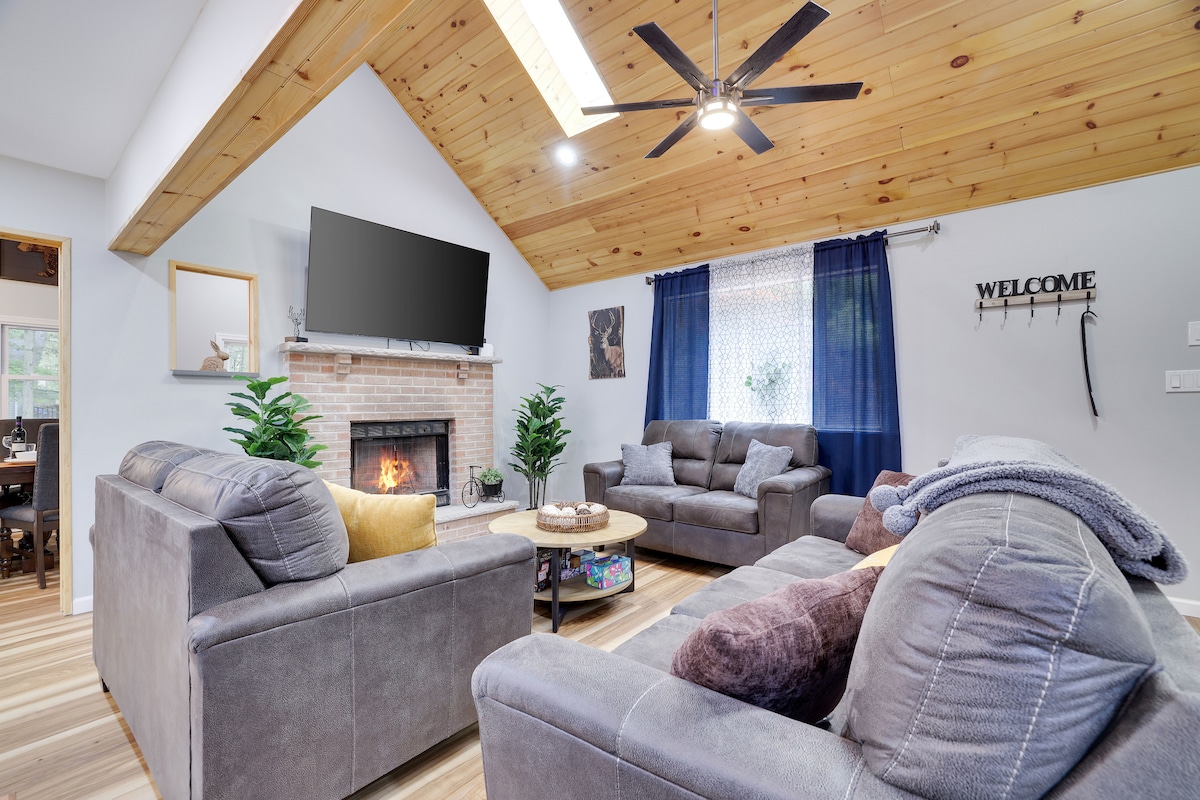Our charming living room area features a 70-inch smart TV, board games, puzzles, magazines, books, and a house guide. Karaoke speaker with 2 microphones are also available, as well as a wood fireplace, comfy couches, and a rustic round table
