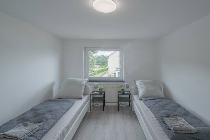 Spálňa s dvoma lôžkami, zásuvkami a televízorom