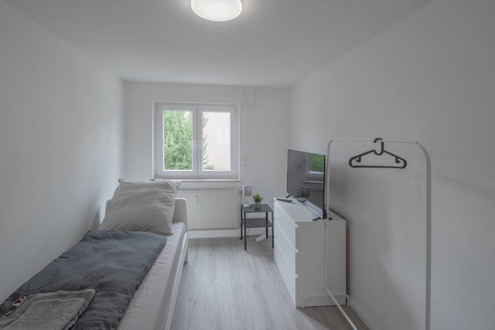 Jednolôžková izba so zásuvkami a televízorom