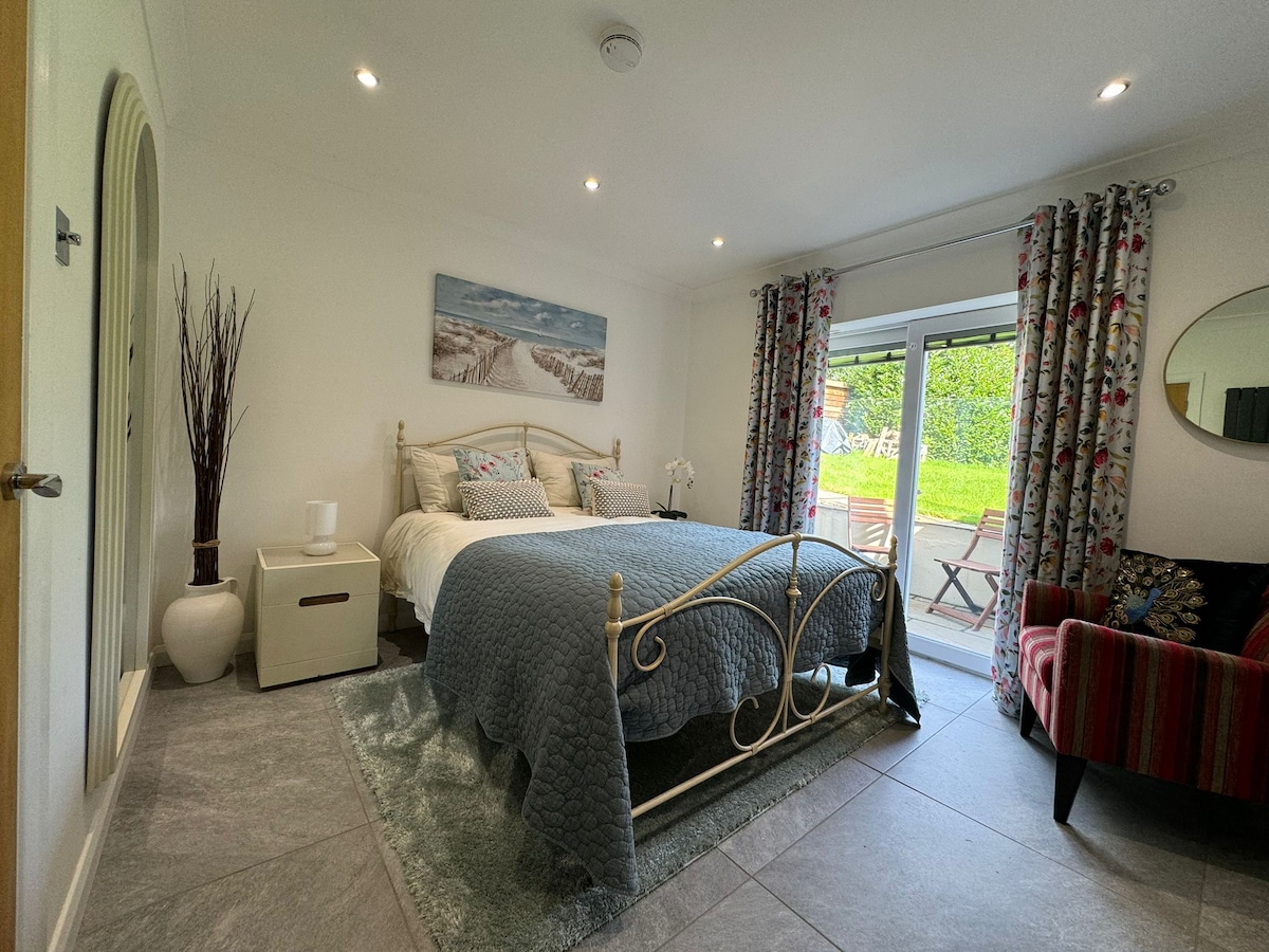 1 cama tamaño queen (5 pies): el dormitorio tiene acceso a una pequeña terraza exterior, que tiene vistas al camino de entrada y al césped compartido (zona de césped ocasionalmente compartida con los anfitriones).