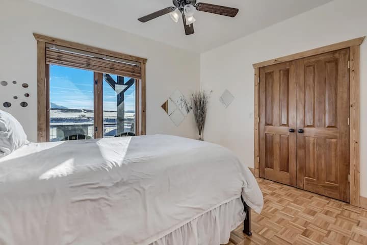 วางศีรษะของคุณเพื่อพักผ่อนบนที่นอนควีนไซส์นี้มีหมอนอวบอ้วนผ้าปูที่นอนเรียบเนียนและวิวทางใต้ที่สวยงาม 