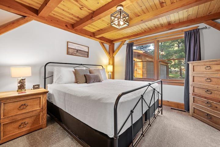 Pata starehe ya hali ya juu katika chumba cha kulala cha ghorofa kuu, ukijivunia kitanda cha kifalme na mandhari ya kupendeza ya nje.