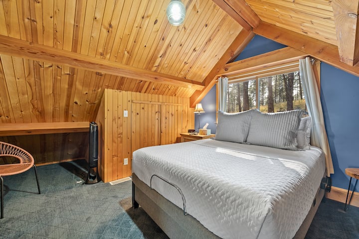 Chumba cha kulala cha roshani cha kupendeza kilicho na kitanda cha kifahari na mandhari nzuri ya nje.