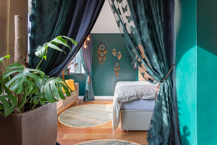 Segundo dormitorio con toques bohemios, atrapasueños y luz natural, un refugio acogedor para parejas o amigos.