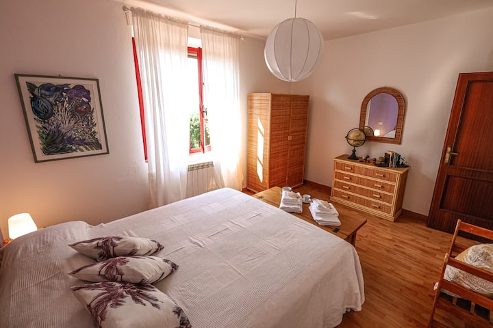 Amplia habitación doble amueblada con muebles de mimbre, que incluye un armario, una cómoda y mesitas de noche. Amplio, tranquilo y luminoso. 