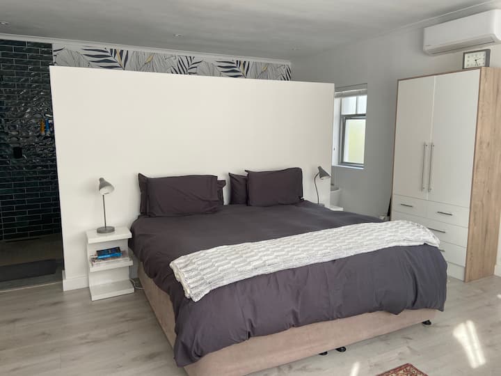 Glavna spavaća soba s bračnim krevetom, kupaonicom otvorenog tlocrta, prostorom za rad i klima-uređajem.