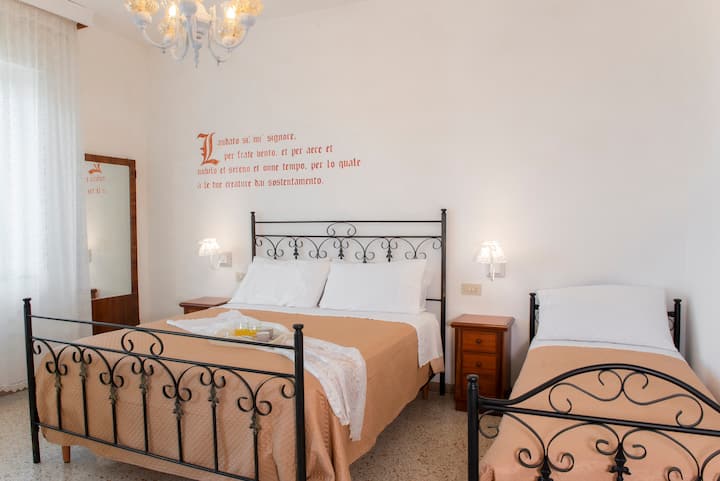 Habitación triple con terraza panorámica y televisión en el segundo piso. Cama doble y cama individual equipada con almohadas dobles, sábanas y mantas.