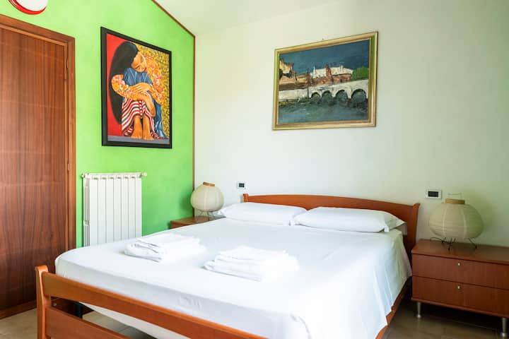 Première chambre double avec lit queen-size, lit simple, climatisation, balcon privé.