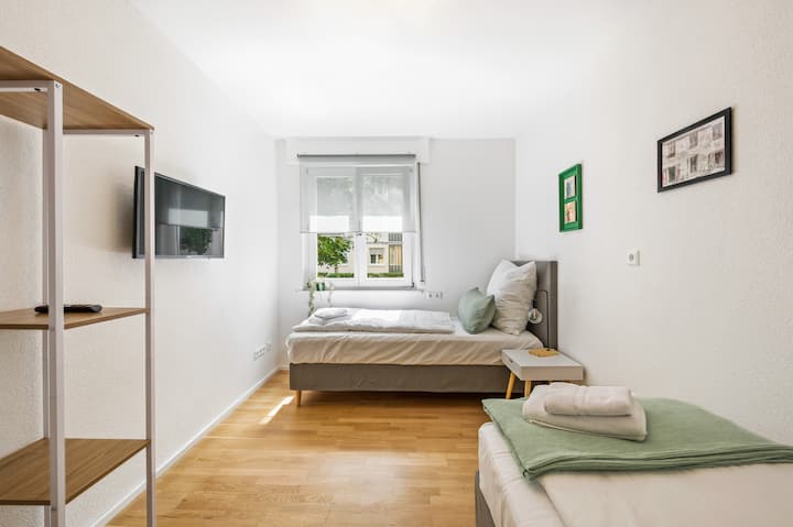 Ნათელი ოთახი ორი ერთადგილიანი საწოლით (ასევე გამოდგება ორადგილიანი საწოლის სახით), ღია გარდერობით, კედელზე მიმაგრებული ტელევიზორით, დიდი ფანჯრით, რომელიც ქალაქგარეთ გადაჰყურებს და საწოლთან მდგარი მაგიდა ლამპით.





