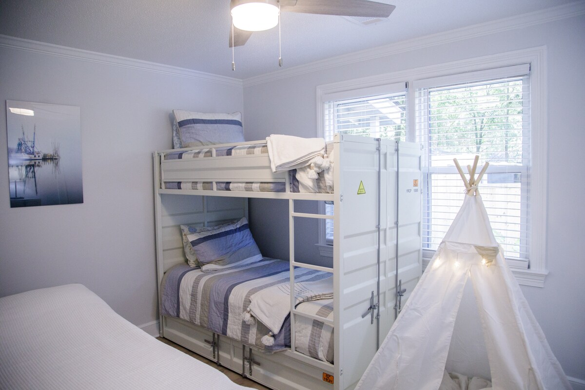 Dormitorio trasero con dos nuevos colchones individuales en camas de contenedor de metal y una nueva cama de tamaño completo si necesitas un poco de espacio adicional.  También un tipi iluminado para que los niños disfruten. 