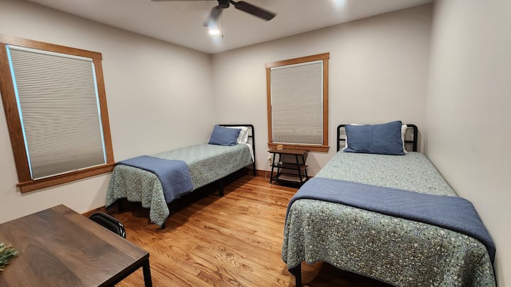 Spálňa na prízemí s dvoma pohodlnými oddelenými posteľami XL a malým písacím stolom na prácu na diaľku. 