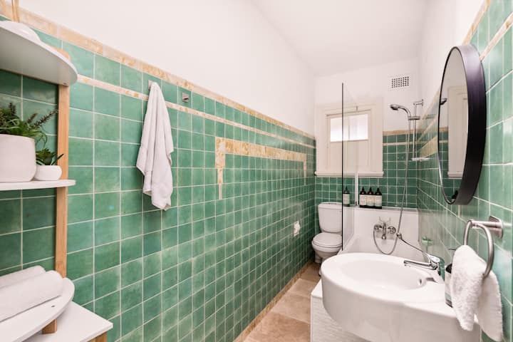 Refresh in the charming bathroom. Featuring vibrant green tiles, modern fixtures, and premium Sukin toiletries, this space offers a relaxing and rejuvenating experience.