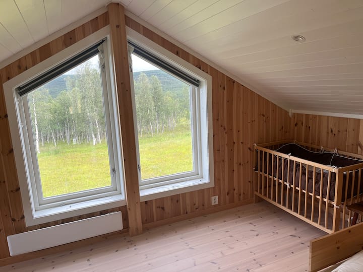 El dormitorio 2 en el loft tiene dos camas individuales (W=80 cm) y una cuna. Ventanas orientadas al este y al norte. Si es la época correcta del año, puedes ver alces pastando en el borde del bosque.