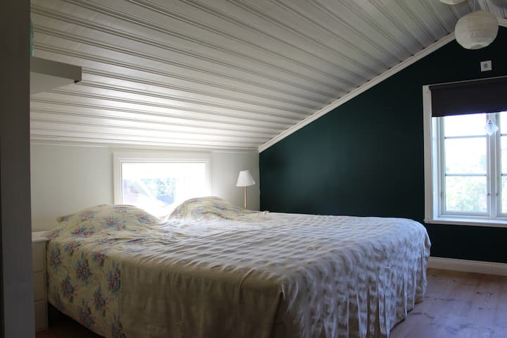 La plus grande chambre avec un grand lit double ainsi qu'un canapé attenant. Il y a aussi un placard vide ainsi qu'un bureau.