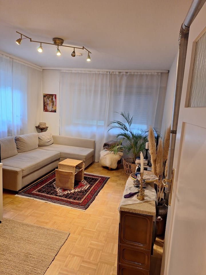 Sala de estar en casa en un bohostil africano oriental con sofá cama extraíble con capacidad para 2 personas.