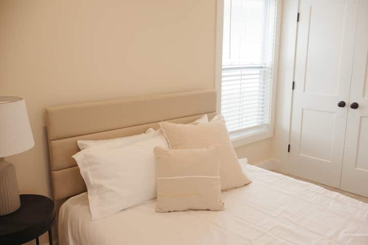 Оваа спална соба на втор кат нуди топли, неутрални тонови, мека постелнина и многу природна светлина, создавајќи мирно и релаксирачко прибежиште.