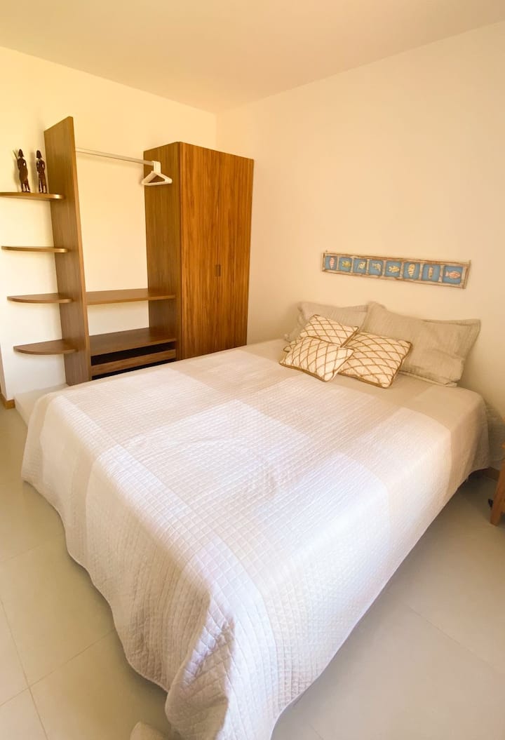 Dhomë gjumi në katin përdhes me krevat dopio "queen" me dritare në ballkonin e shtëpisë.