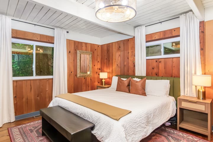 King bed on main level of house, black out curtains, sound machine, and charging ports in lamps