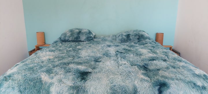 Espaciosa habitacion con cama King y espacio para dejar la ropa.