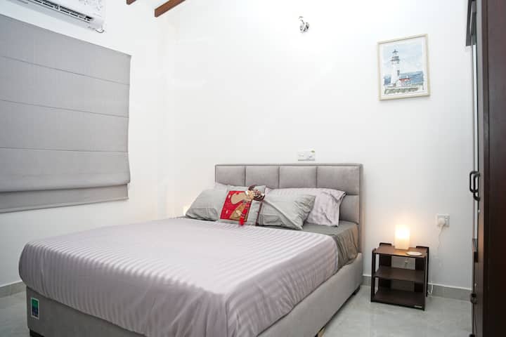 Kjo dhomë gjumi ka një krevat të rehatshëm me madhësi dopio "queen" me kokë të veshur me susta gri. Dhoma përfshin A/C, tavolinë anësore moderne me abazhur, gardërobë, vepra arti të farit dhe grila dritaresh gri. E përkryer për një natë të qetë pushimi.