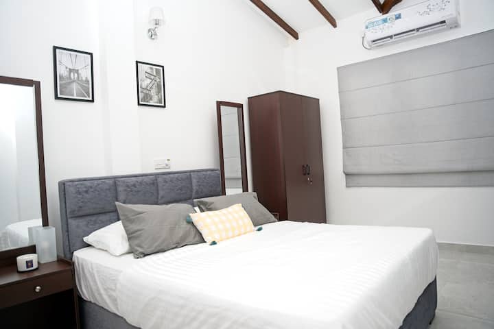 Kjo dhomë gjumi kryesore e ndritshme dhe e ajrosur lart ka një krevat të rehatshëm, jastëkë të butë dhe çarçafë të bardhë të pastër. Ka një gardërobë për rrobat e tua, një pasqyrë për t 'u përgatitur dhe ajër të kondicionuar për të të mbajtur të freskët. Një hapësirë e qetë dhe e rregullt për t 'u çlodhur.