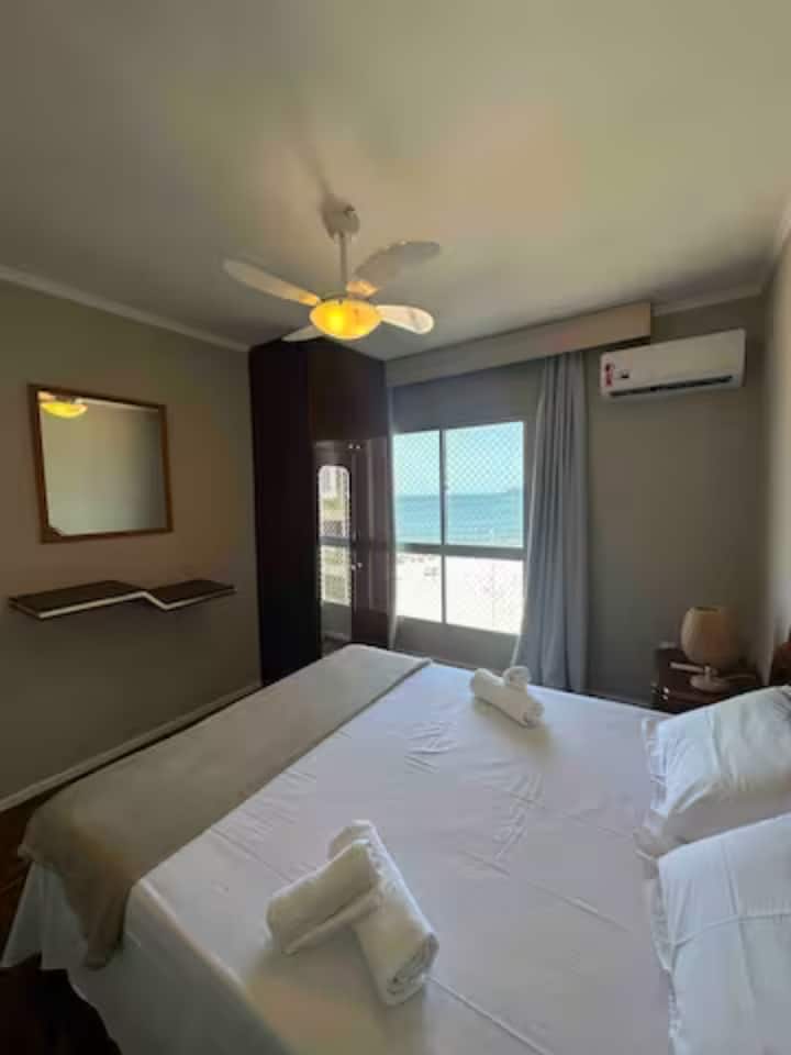 Soba s podijeljenim novim klima-uređajem i stropnim ventilatorom, pogled na plažu.