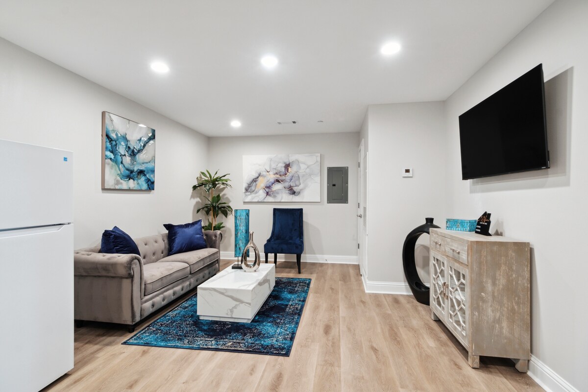 Unit 2B Living Space - plaatsinstellingen voor 4, gemonteerde HDTV met streamingdiensten, bank en stoel, met zorg ontworpen, naast de keuken