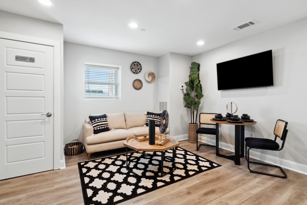 Unit 2D Living Space - plaatsinstellingen voor 4, gemonteerde HDTV met streamingdiensten, bank en tafelopstelling, met zorg ontworpen, naast de keuken