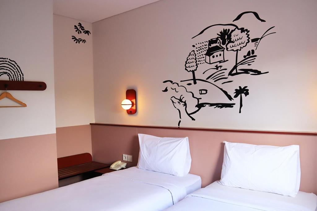 A double room is presented with two spacious beds, adorned with crisp white linens. A minimalist mural of a landscape decorates one wall, while wooden hangers are available for convenience. Soft lighting fixtures enhance the overall ambiance. A small seating area is visible in the corner.