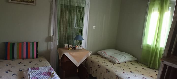 שתי מיטות יחיד וארון בגדים כפול, מסכים ומאוורר