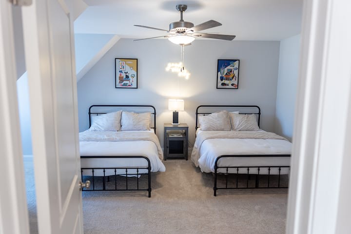 Dormitorio #3 arriba con dos camas completas, mesita de noche con cargador USB, lámpara, escritorio, silla y ventilador de techo. #¡Solo buena vibra!