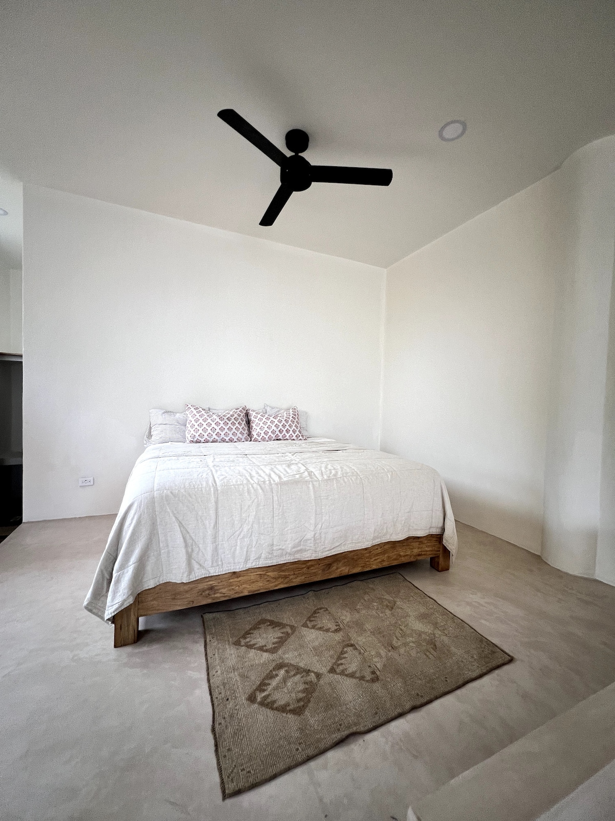 Cama tamaño king. En un diseño de estudio abierto. Las escaleras conducen a la plataforma de la cama.