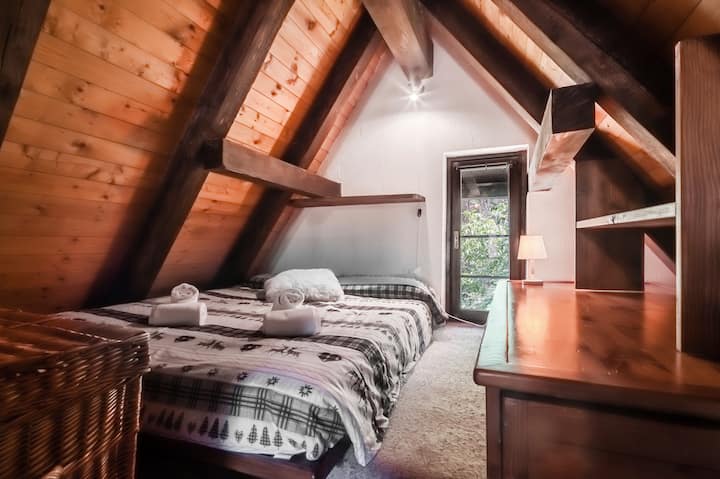Quatrième chambre à coucher à l'étage mezzanine avec lit double Queen size, lit simple, chauffage, commode, fauteuil et couvertures supplémentaires.
Accessible par un escalier depuis le salon.
