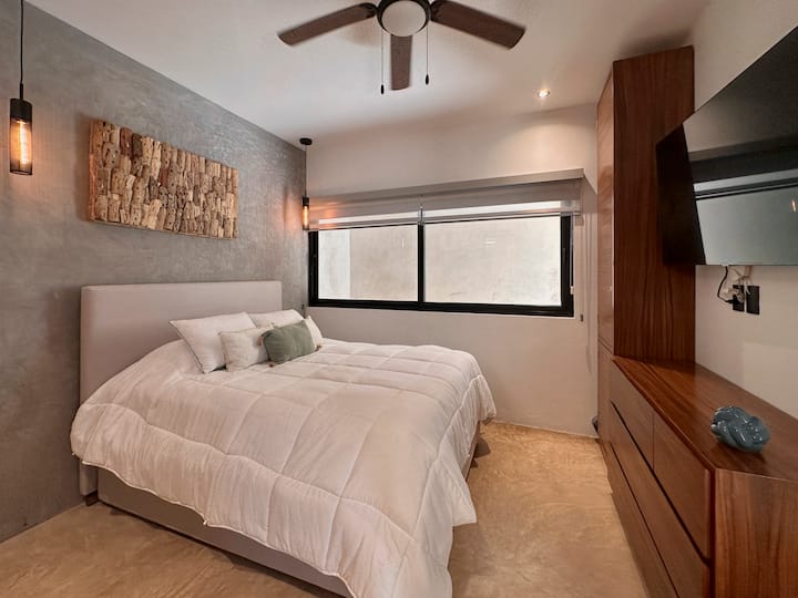 Mwonekano wa jumla zaidi wa chumba na kitanda cha starehe na chenye nafasi kubwa. Kitanda cha kangaroo cha ukubwa wa malkia