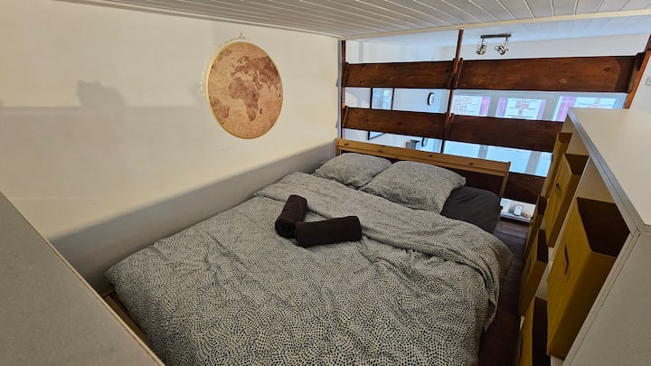 Quarto com cama de casal localizado no mezanino acessível a partir da sala de estar.