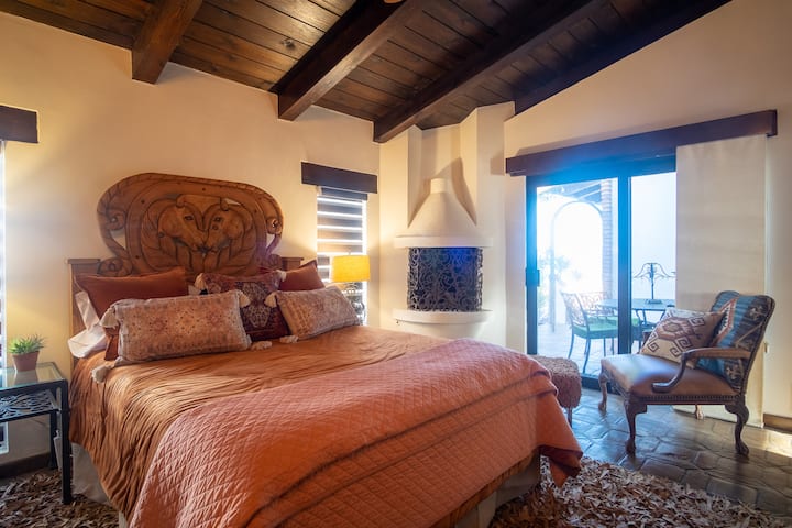 Primary Bedroom upstairs with Queen bed and on suite bathroom and an ocean view through the patio