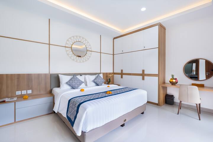 The bedroom features a comfortable king-size bed, air conditioning for a cool and relaxing stay, a safe deposit box for security, a wardrobe for ample storage, a desk with a chair, and a TV for entertainment. 